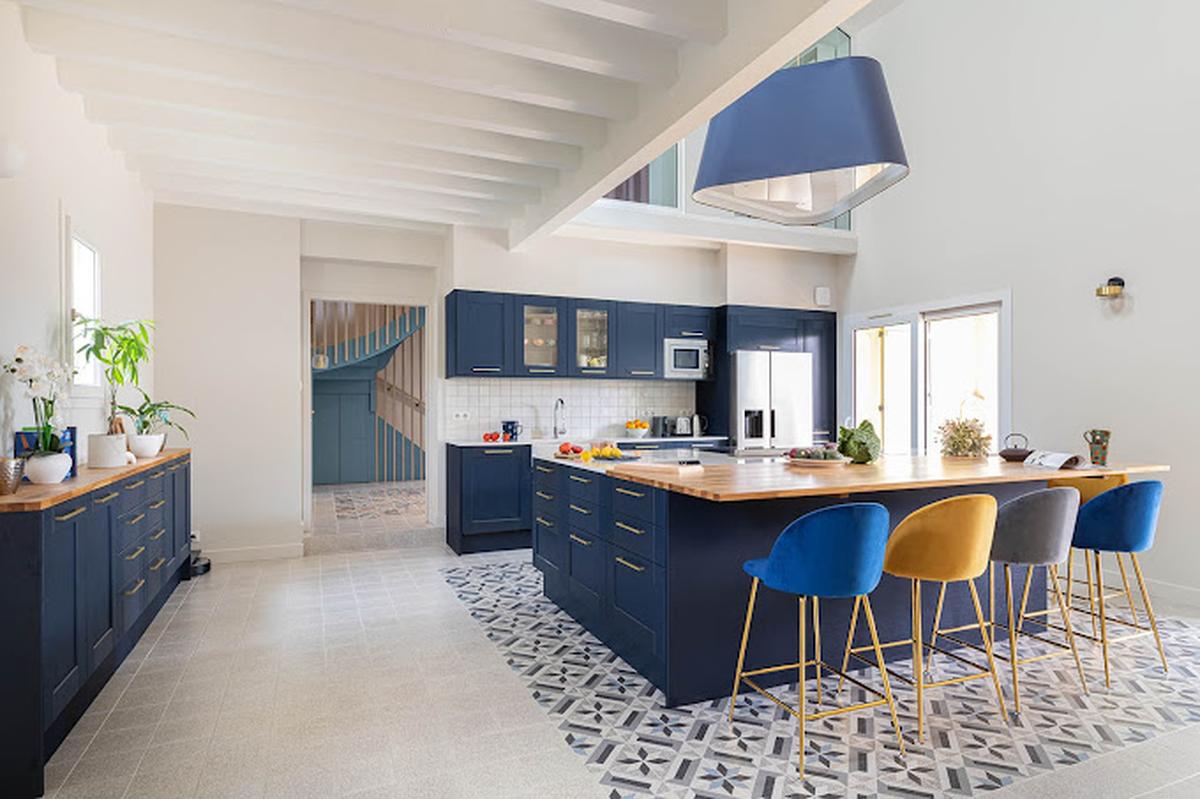 Cuisine moderne rénovée avec ilot central bleu et chaises colorées - projet Deep Design